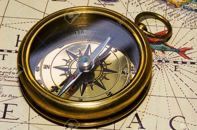 649930 old style gold compass on antique map